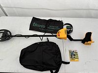 Complete Garrett ACE 250 detector with headphones, backpack, Kellyco bag, manual displayed on table