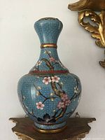 Front view of blue cloisonné vase showing floral and bird motif and overall shape