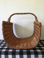 Front view showing woven wicker basket upright with handle