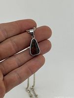 Close-up of ammolite pendant showing gemstone colour and sterling bezel