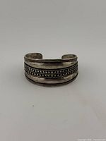Front view of sterling cuff bracelet showing decorative beaded and rope borders
