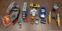 Overview of entire lot showing Lego ship parts, instruction booklet, vehicles, RC police car, Podracer, remote and die-cast cars