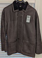 Front view of dark brown shearling leather coat hanging on hanger