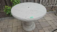 Full view of round grey faux-stone patio table