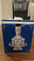 front of original blue box showing image of wine fountain and goblets
