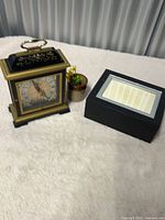 Full view of mantel clock and trinket box on surface