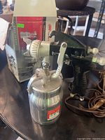 Ingersoll Rand 210GSA spray gun with attached aluminum paint cup and original box visible