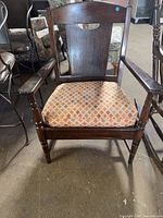 Front view of dark brown wooden armchair with diamond-pattern upholstered seat
