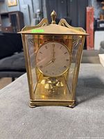 Front view of brass and glass anniversary clock