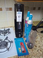 SodaStream maker, two CO₂ cylinders, bottle, manual