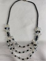 Full view of necklace showing three strands, bead types, clasp