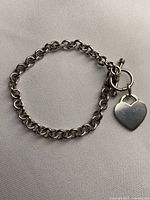 Full view of sterling silver link bracelet with heart charm
