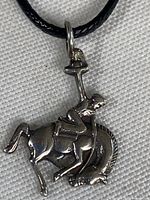 Full view of sterling silver bronc rider pendant on cord