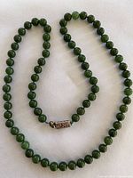 Full view of jade bead necklace laid flat showing beads and clasp