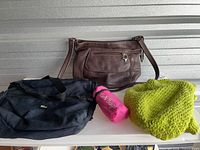 All four items grouped: leather purse, duffel, foldable bag, knit hat