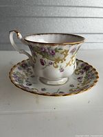 Teacup on saucer showing pattern and gold trim