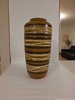 Full front view of striped ceramic floor vase