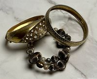 Lot overview showing hinged rhinestone bangle, textured slip-on bangle and stretch beaded bracelet