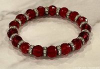 Top view of full bracelet showing red glass beads and rhinestone spacers