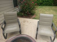 Photo showing the pair of Hampton Bay outdoor rocking chairs placed on a patio, with beige mesh fabric and metal frame visible.