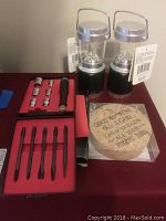 Small socket set including metric and imperial sockets with ratchet and adapters in foam-lined case, two mini lanterns, and coasters