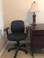 Blue ergonomic desk chair with cushioned backrest and armrests, black five-wheel base.