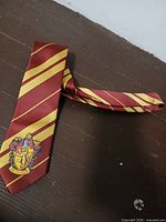 Full view of red and gold diagonal striped necktie laid flat