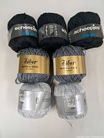 Front view of all seven skeins showing brands, colors, labels