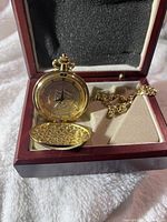 Watch open in presentation box showing dial, chain and interior lining