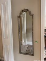 Full view of tall wall mirror mounted between walls