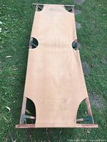 Full view of unfolded cot on grass