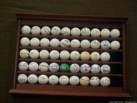 Full view of rack holding 40 signed golf balls
