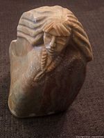 Full view of stone sculpture showing southwest figure bust