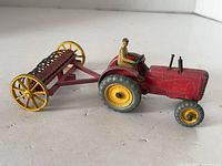 Left side view of tractor hitched to harrow