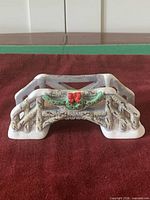 Front view of resin rustic bridge figurine with snow accents and garland