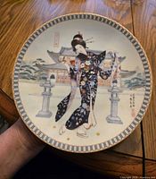 Full view of porcelain plate front with artwork and rim pattern