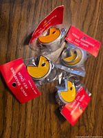 All four sealed Pac-Man pencil sharpener key chains on wood surface