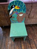 Front view showing toucan and monkey art on chair back and green seat