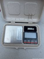 Scale and calibration weight inside beige case