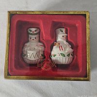 Closed Lenox box with two snowman toy soldier shakers visible in red velvet insert