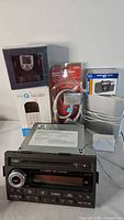 Group shot of multiple boxed items, car stereo head unit, cables
