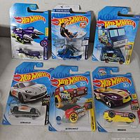Front view of six packaged Hot Wheels cars arranged in two rows