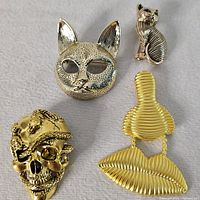 overview of four gold-tone brooches