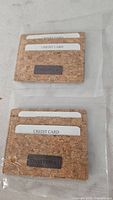 Both Twisted X cork wallets front view in sleeves showing card slots and logo