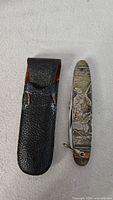 Pocket knife beside leather sheath