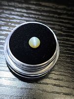 Gemstone in display case showing cat’s eye effect