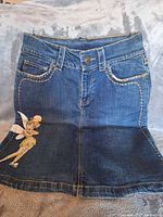 Front view of denim skirt showing Tinker Bell graphic and overall design