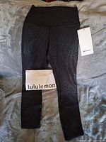 Front view of black tonal leopard print Lululemon Align HR Pant with tags and branded tissue
