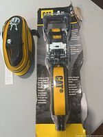 Retail-carded CAT ratchet strap with visible logo and hardware