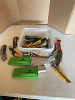 Overall lot with container, hook knives, guards and multiple utility knives on table